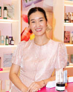 Woman sitting at a table with products in the background