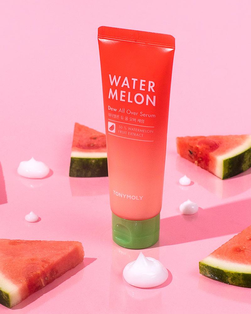 TONYMOLY Watermelon Dew All Over Serum lifestyle picture with watermelon slices around the bottle, which has watermelon themed coloring